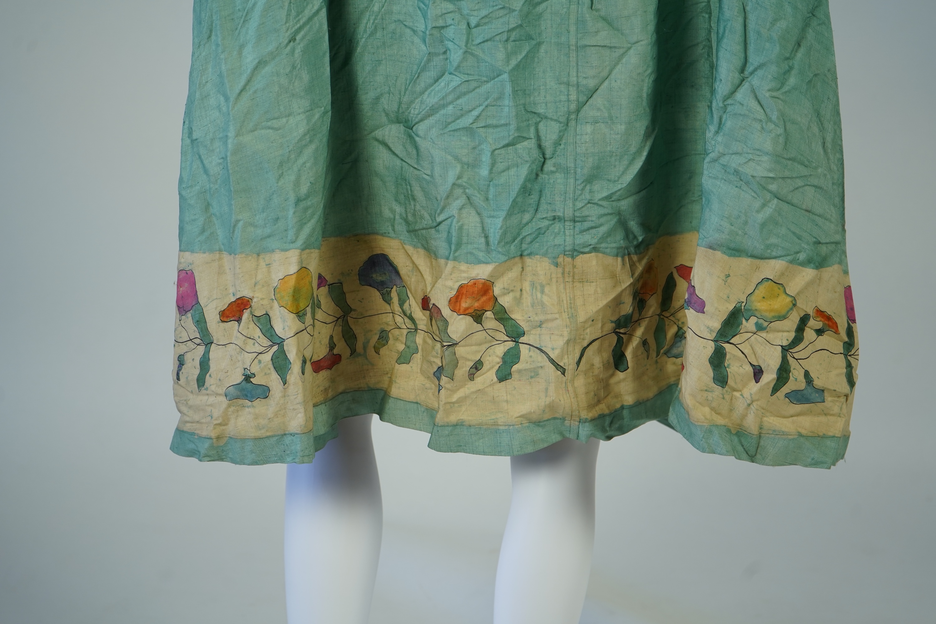 A 1920’s light green silk evening cape with hand batik borders and label: Tito de Canival Mode, together with a navy ladies two piece suit and a maroon satin evening dress. Cape 100cm long. Condition - cape good, navy tw